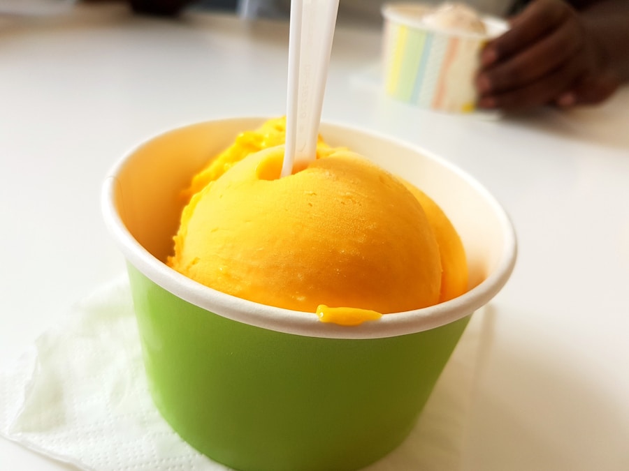 Bright orange sorbet scoop in a green cup