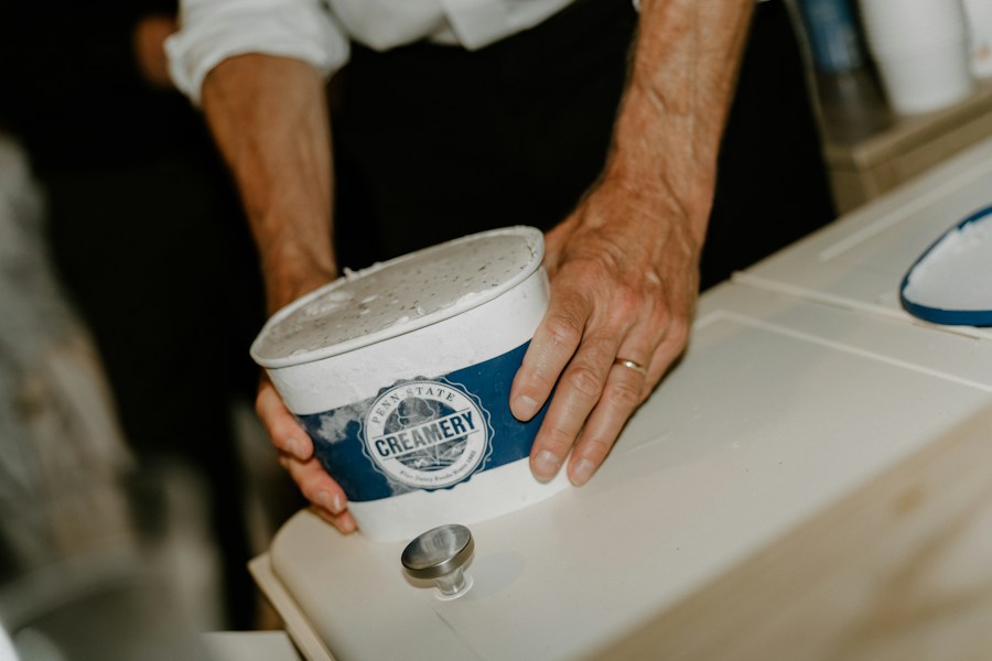 Hands holding a takeaway tub of ice cream